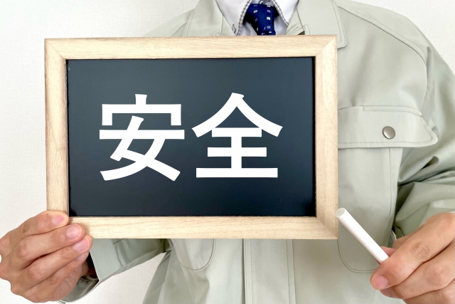 安全と書かれた黒板を持つ男性