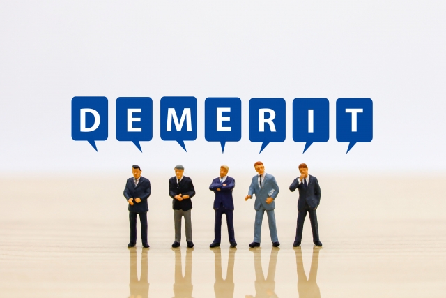 デメリットの文字とビジネスマンたち